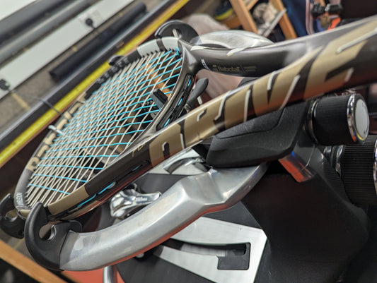Babolat Pure Drive tennis racket mounted on a Wilson Baiardo stringing macine