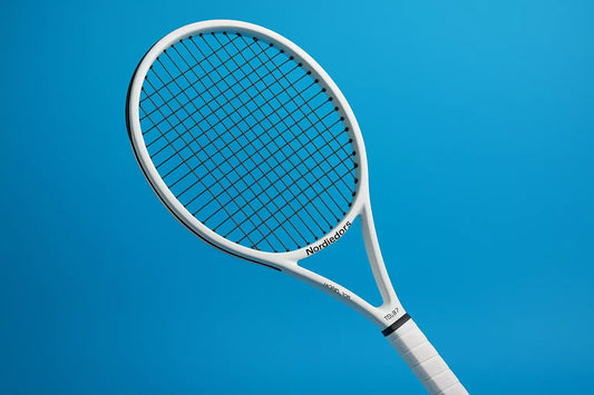Nordicdots Model 100 tennis racket in white with Nordicfots TS127 strings in black, with a blue background and anti clockwise racket orientation to the left