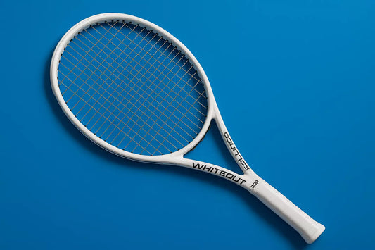 Solinco Whiteout 305 V2 tennis racket with Solinco Tour Bite strings in silver, on a blue background with an anti-clockwise rotations of the racket