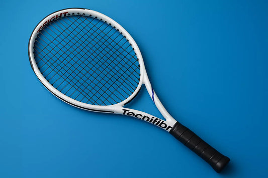 Tecnifibre T-Fight tennis racket with Tecnifibre synthetic gut strings in black on a blue background with an anti clockwise rotation of the racket