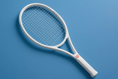 Wilson Shift tennis racket in white with a left rotation, anti clockwise with Weiss Cannon strings in a clear colour, on a blue background